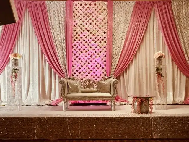 Pink lattice reception stage with gold sequin skirt · Dream Decorators