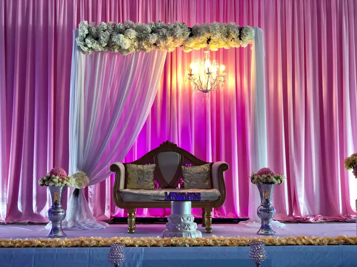 Pink reception stage with crystal chandelier · Dream Decorators