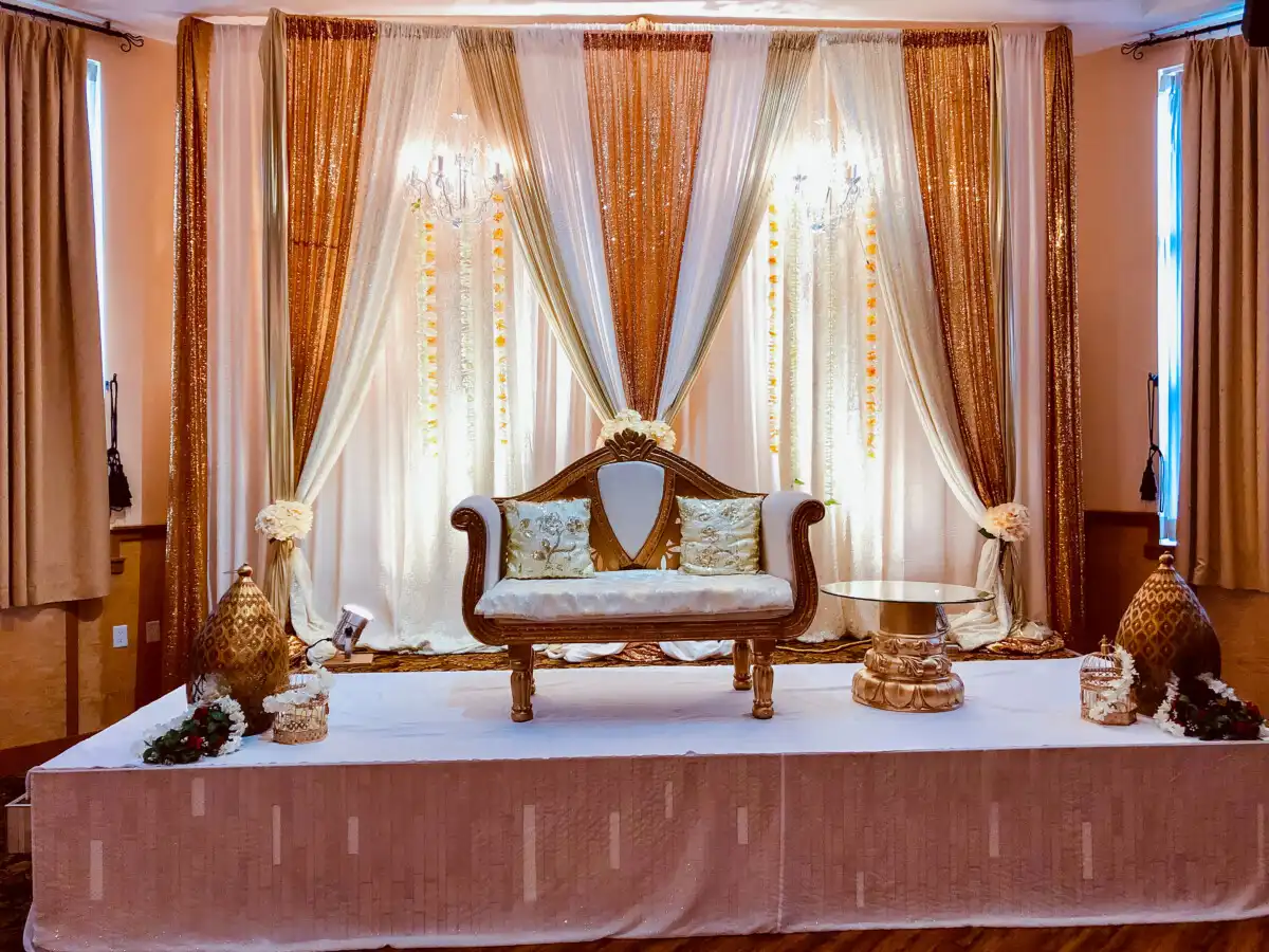 Gold and white sequin reception stage with loveseat · Dream Decorators