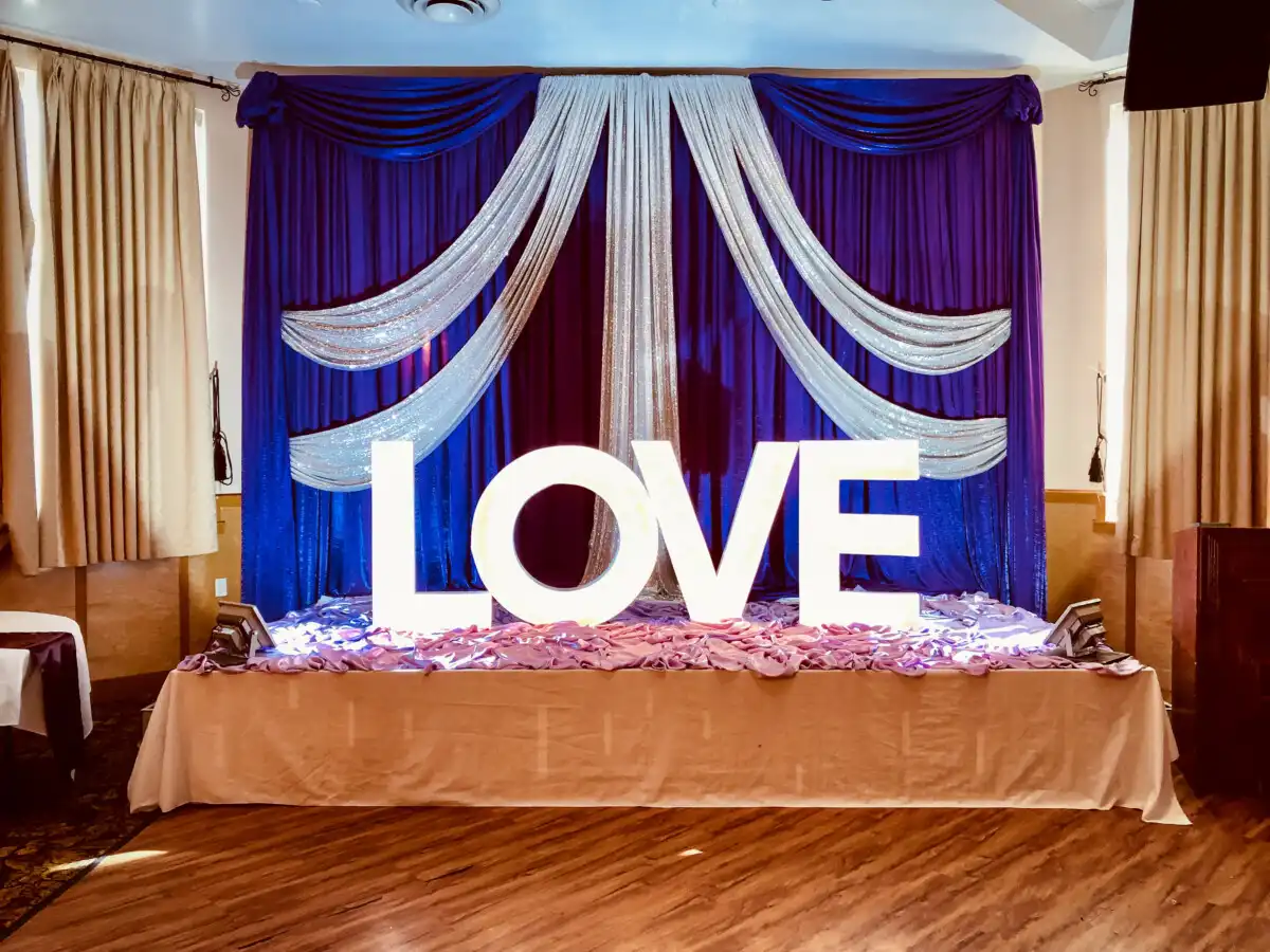 Royal blue and silver LOVE marquee stage backdrop · Dream Decorators