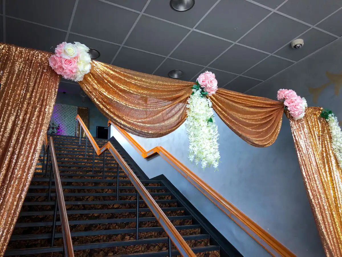 Gold sequin staircase entrance with pink roses · Dream Decorators