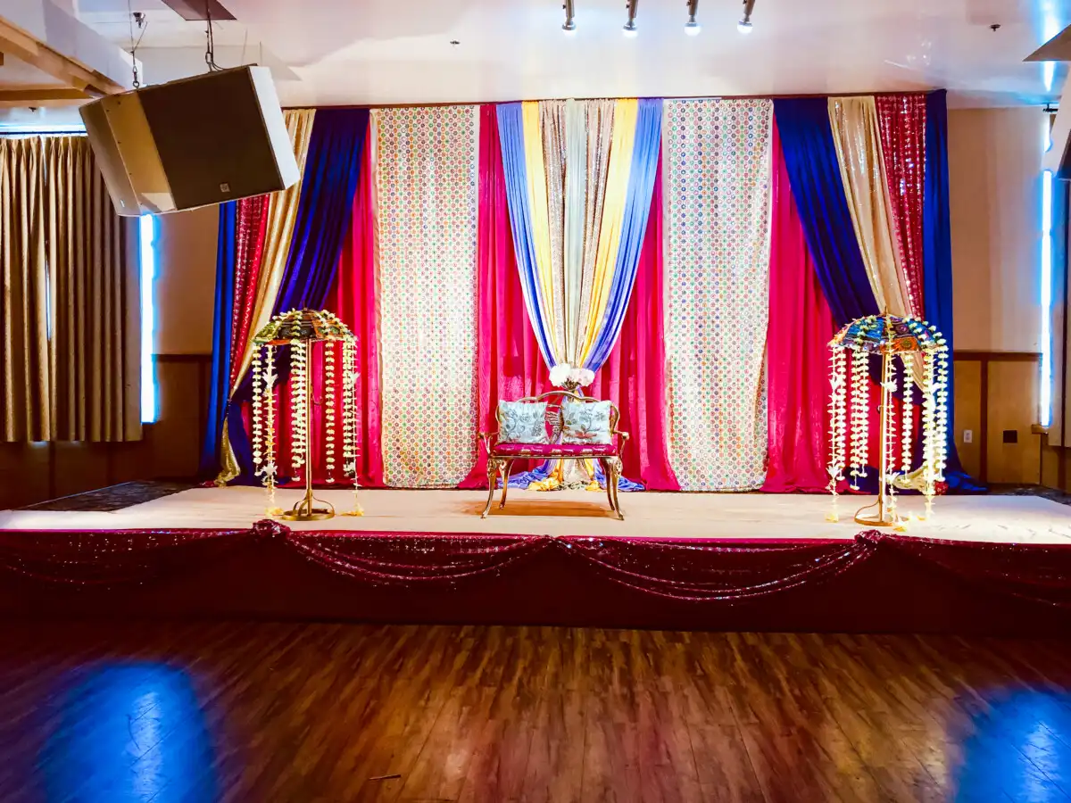 Royal blue and magenta sangeet stage with umbrellas · Dream Decorators