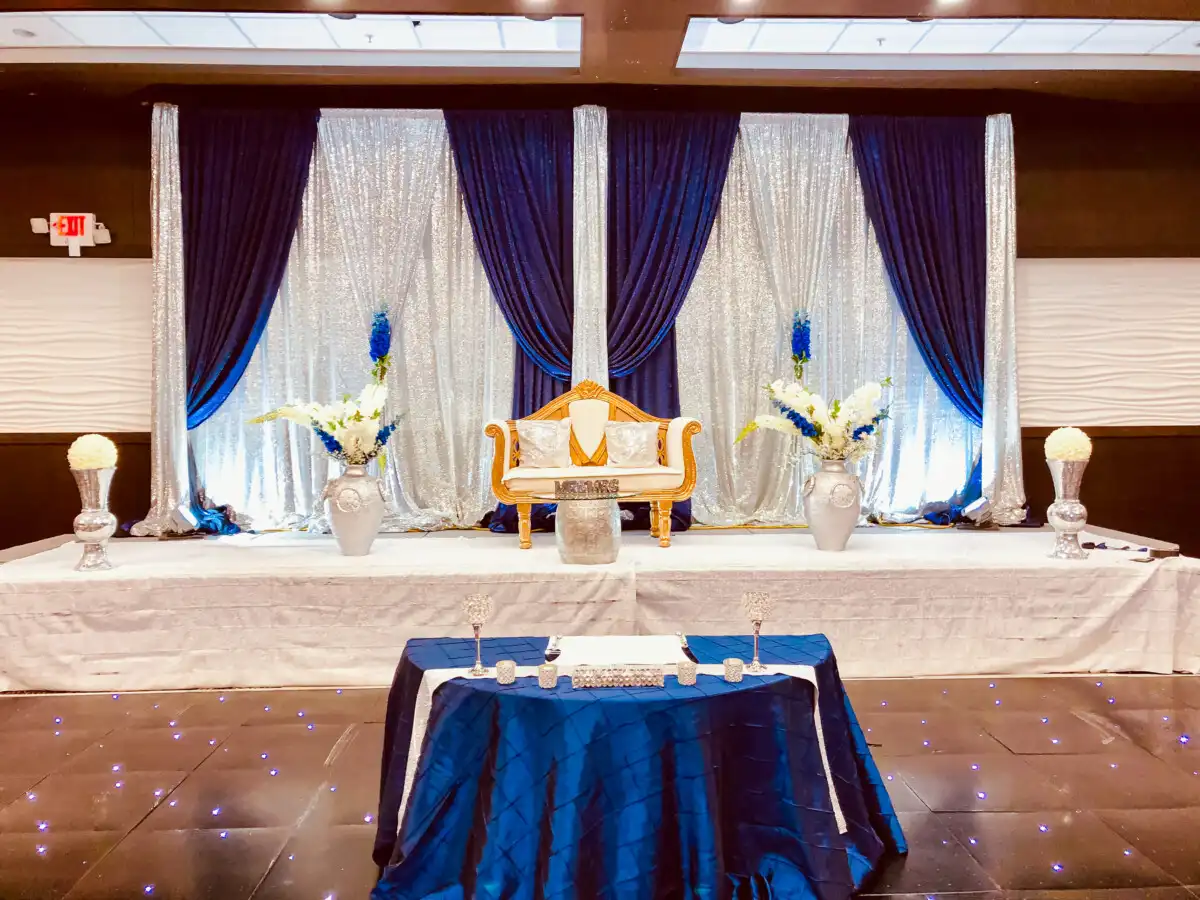 Royal blue and silver reception stage with loveseat · Dream Decorators