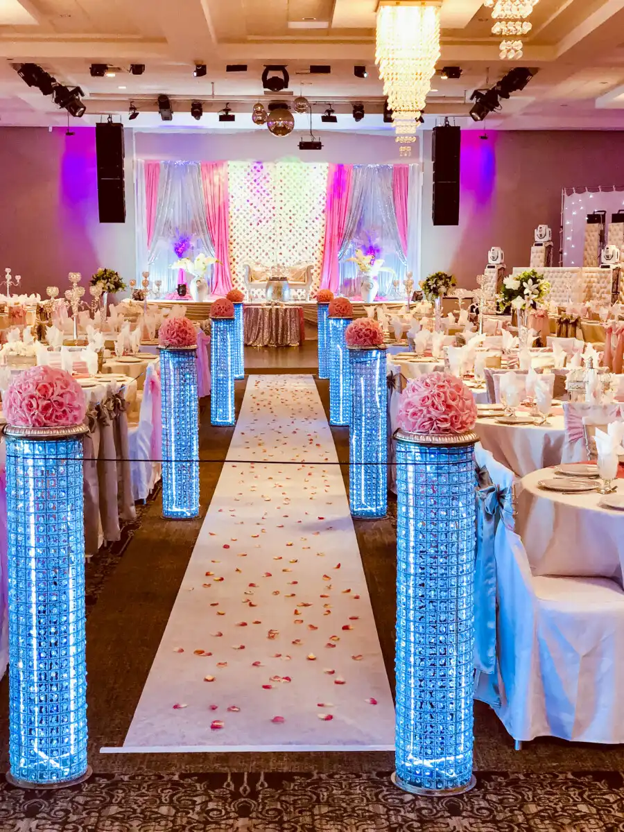 Blue crystal pillar aisle with pink reception stage · Dream Decorators Surrey