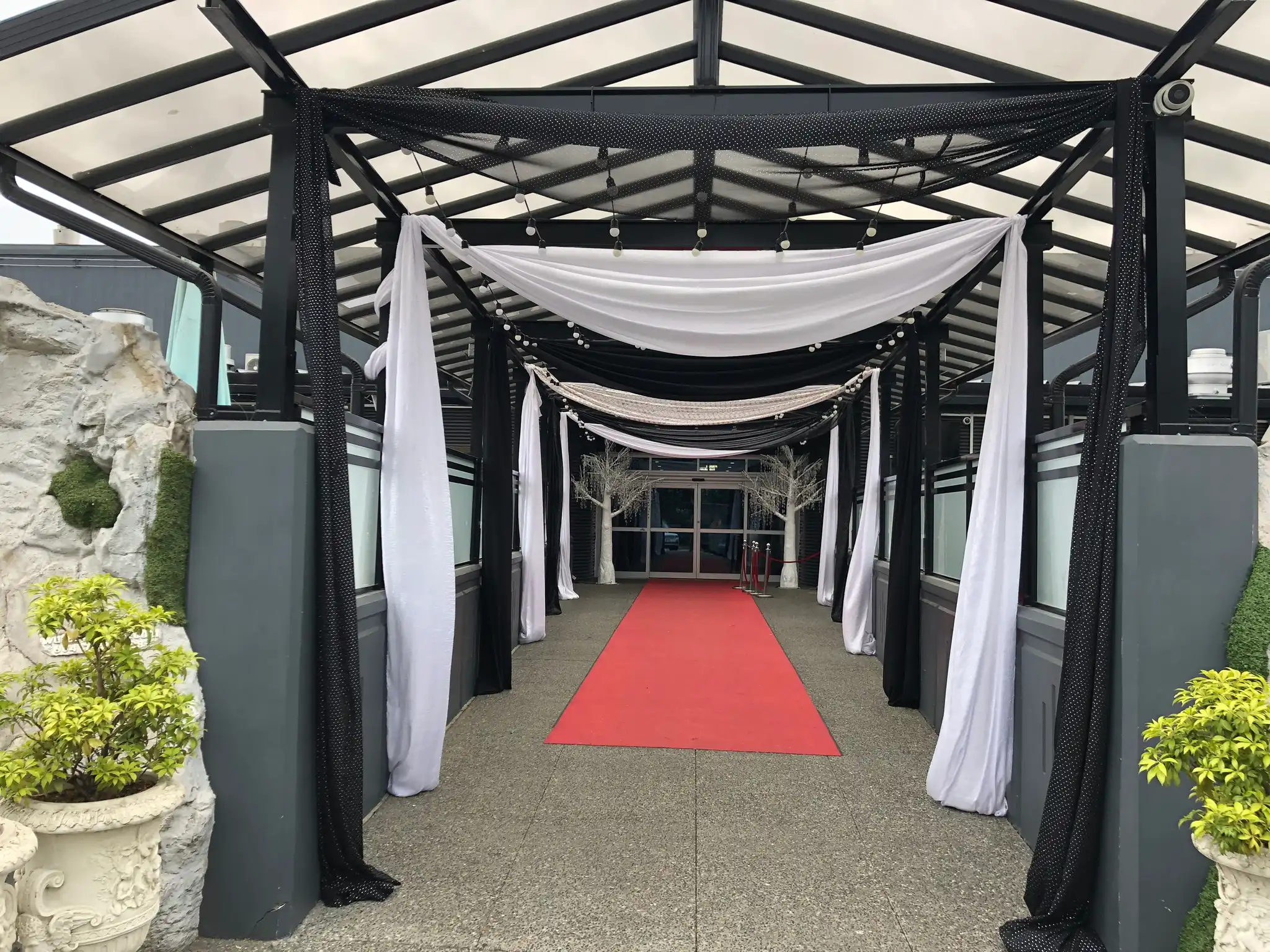 Red carpet entrance with black and white draping · Dream Decorators