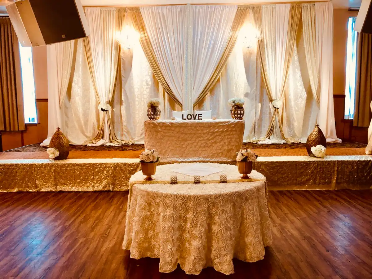 Cream and gold reception head table with LOVE sign · Dream Decorators