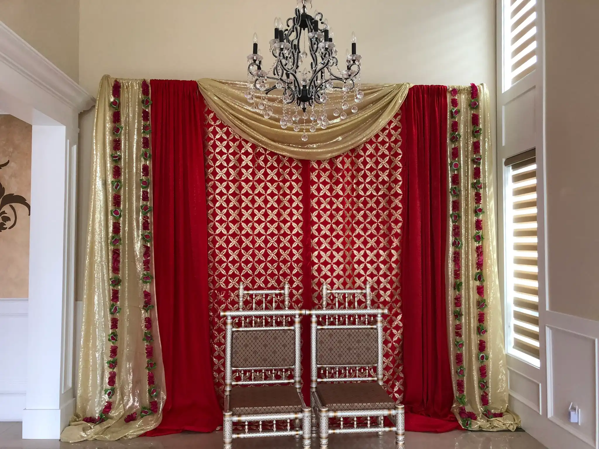 Red and gold home ceremony backdrop with silver chairs · Dream Decorators