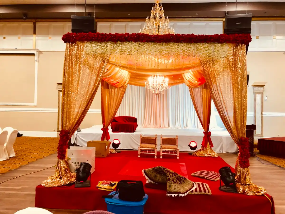 Gold mandap with red rose floral canopy · Dream Decorators
