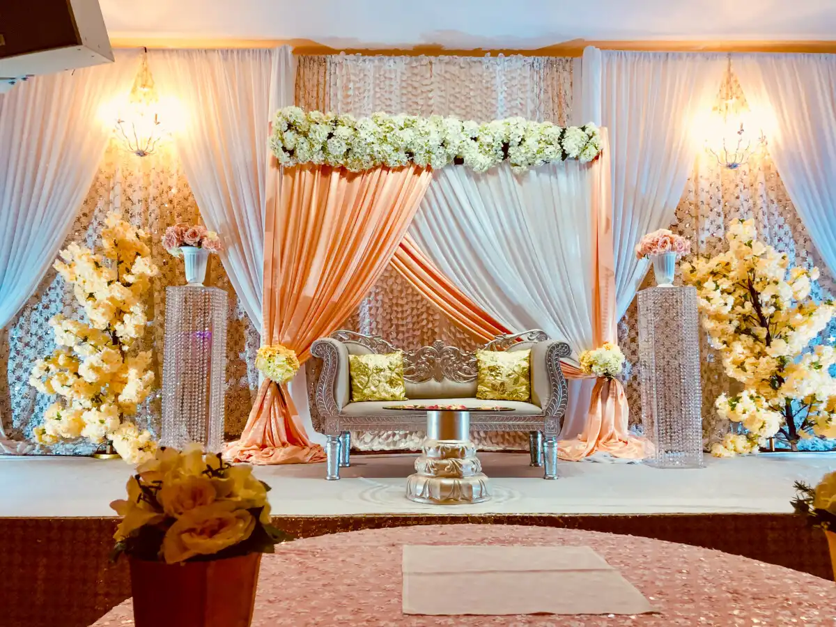 Peach and silver reception stage with blossom trees · Dream Decorators