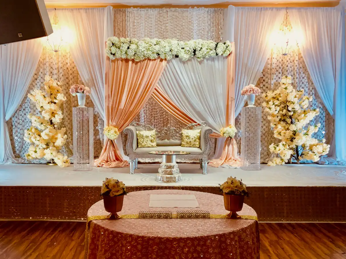 Peach and silver floral canopy reception stage · Dream Decorators