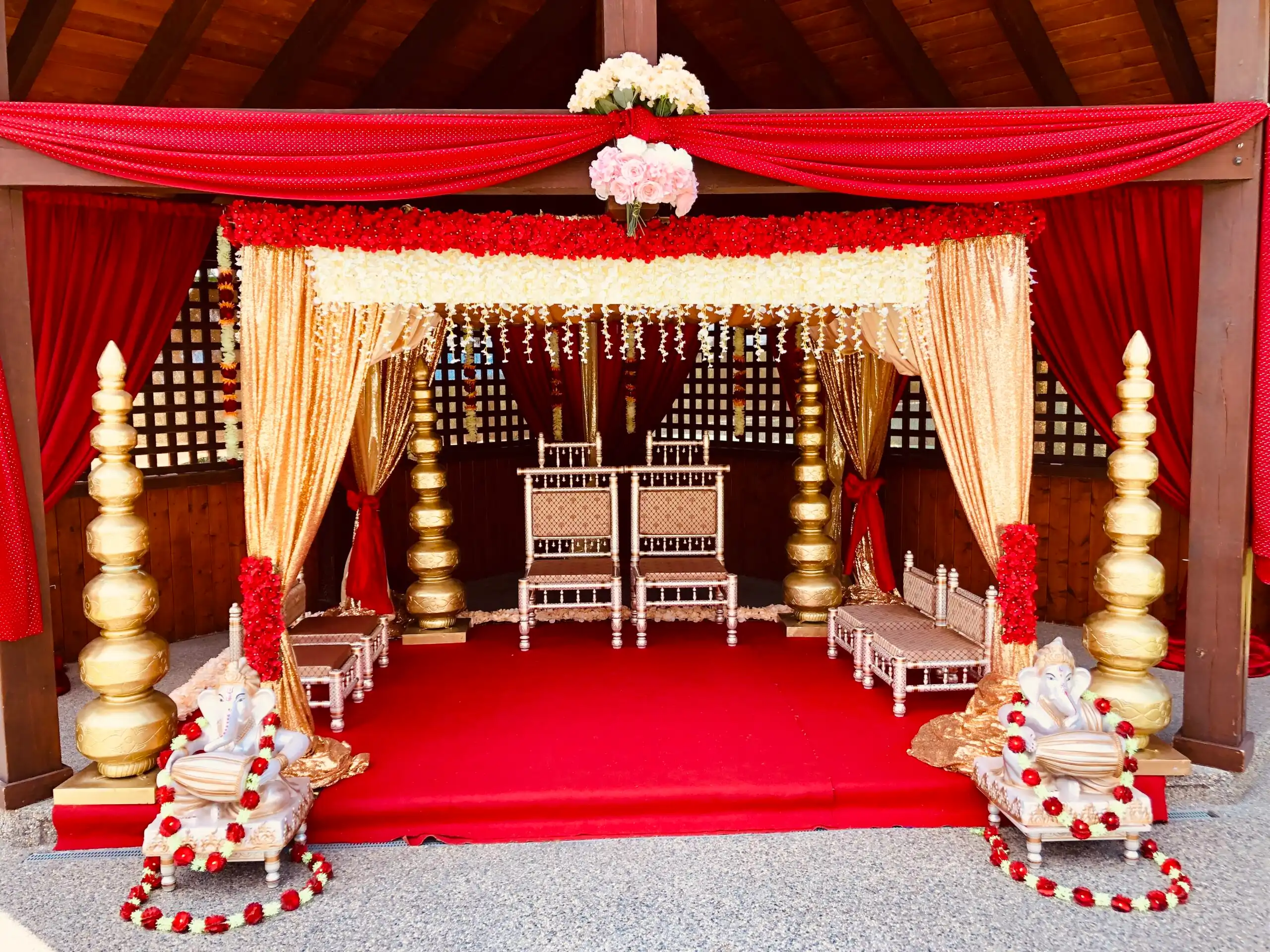 Red and gold gazebo mandap with Ganesha statues · Dream Decorators
