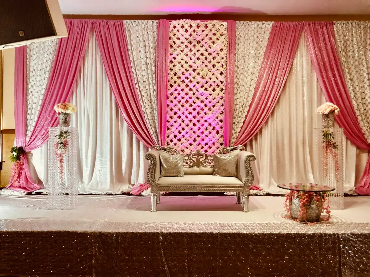 Pink lattice reception stage with silver sequin apron · Dream Decorators