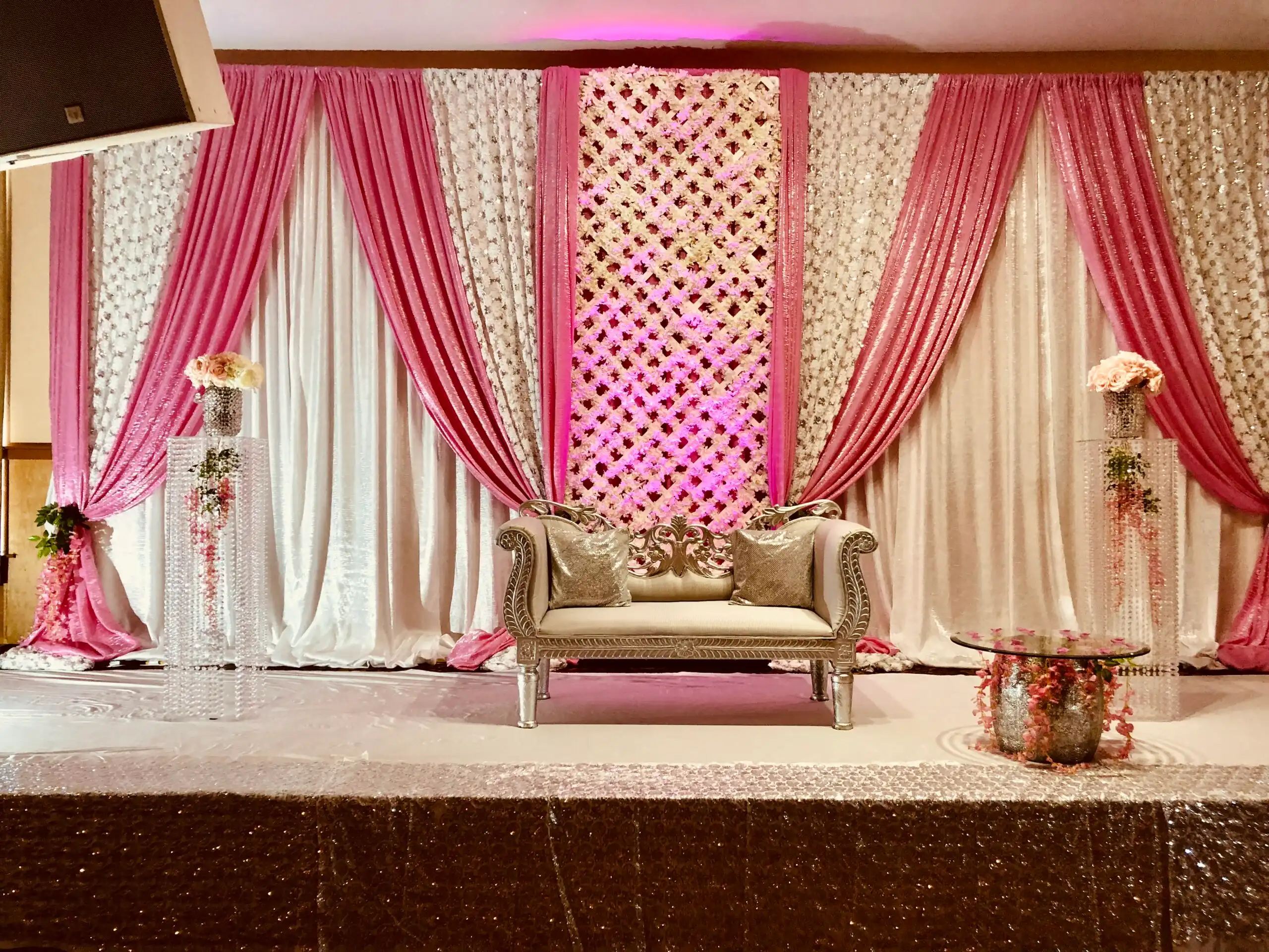 Pink sequin reception stage with silver loveseat · Dream Decorators
