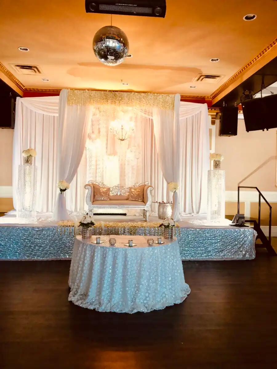 White and silver sequin reception stage with ornate sofa · Dream Decorators