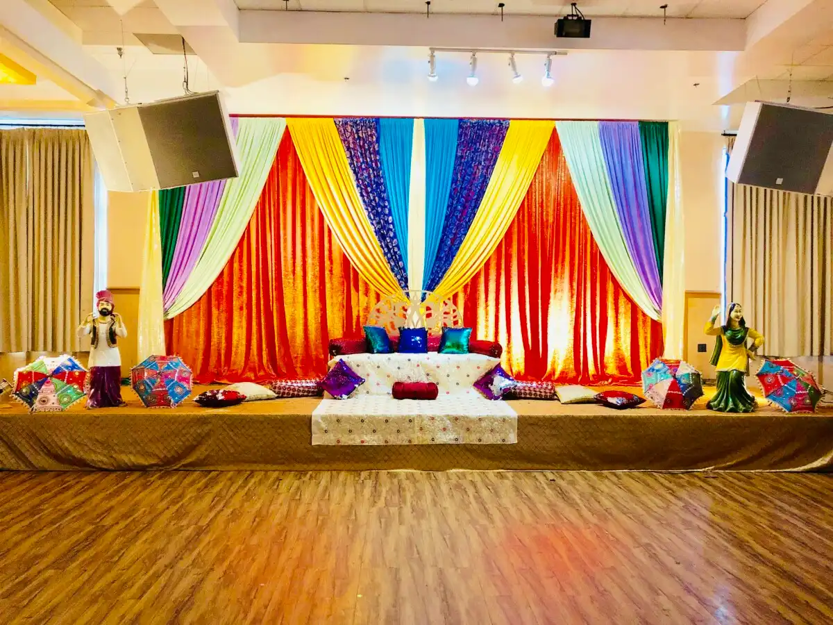 Rainbow Punjabi sangeet stage with folk statues · Dream Decorators