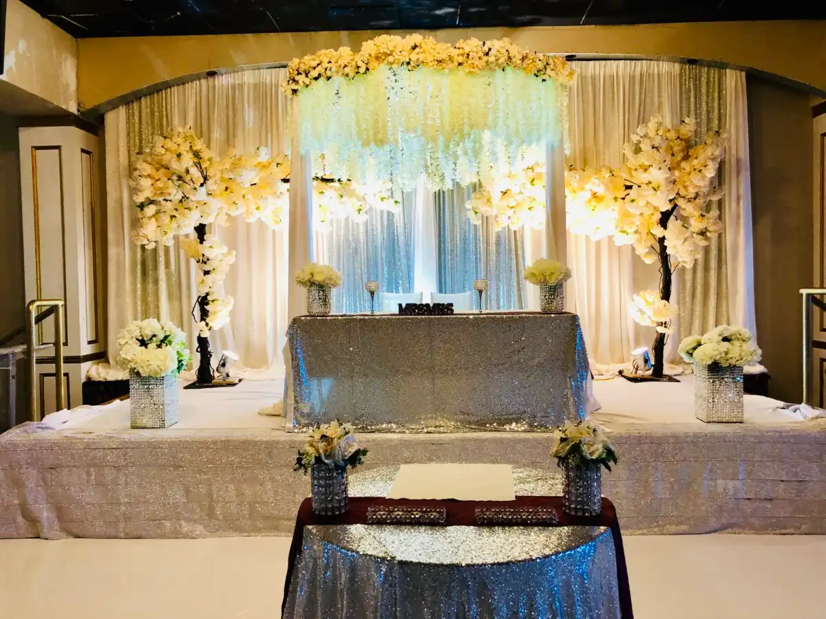 White and silver sweetheart stage with wisteria canopy · Dream Decorators
