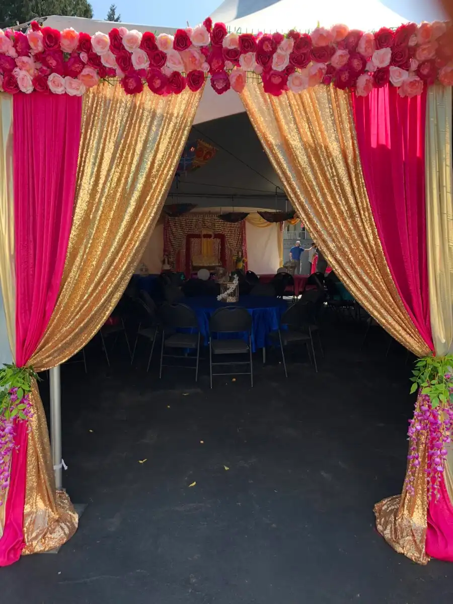Pink and gold tent entrance with rose garland header · Dream Decorators