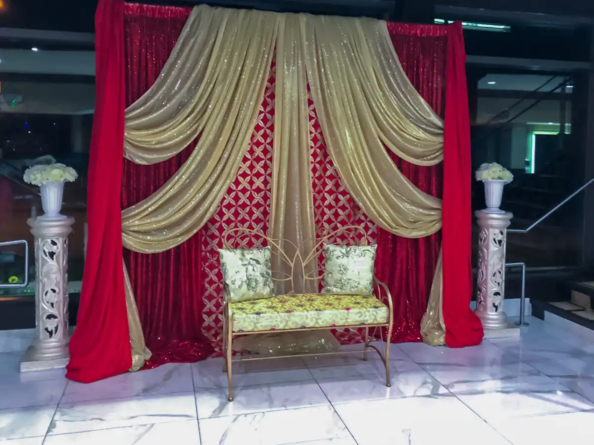 Red and gold sequined stage with gold bench · Dream Decorators