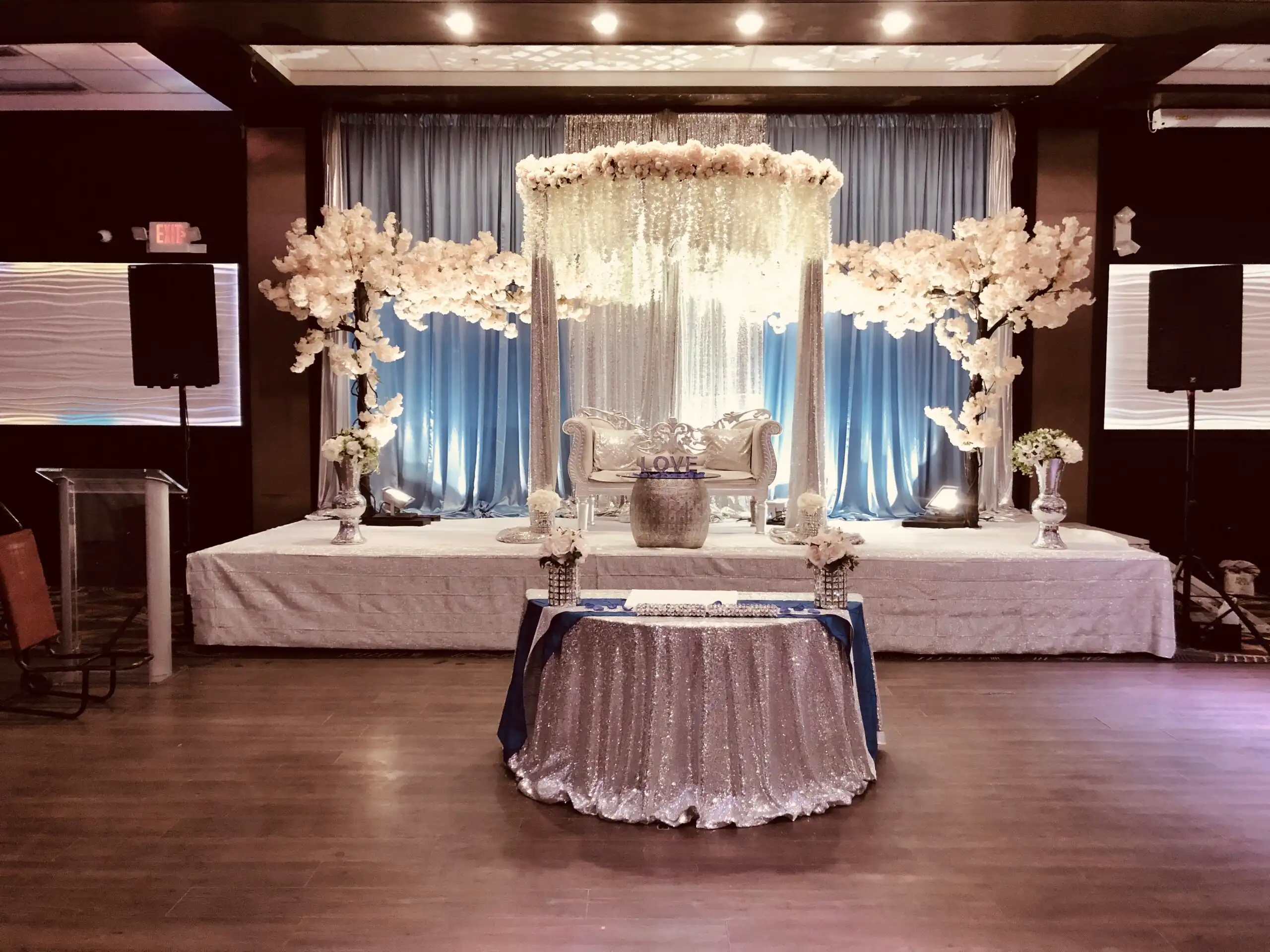 Blue and silver reception stage with cherry blossom trees · Dream Decorators