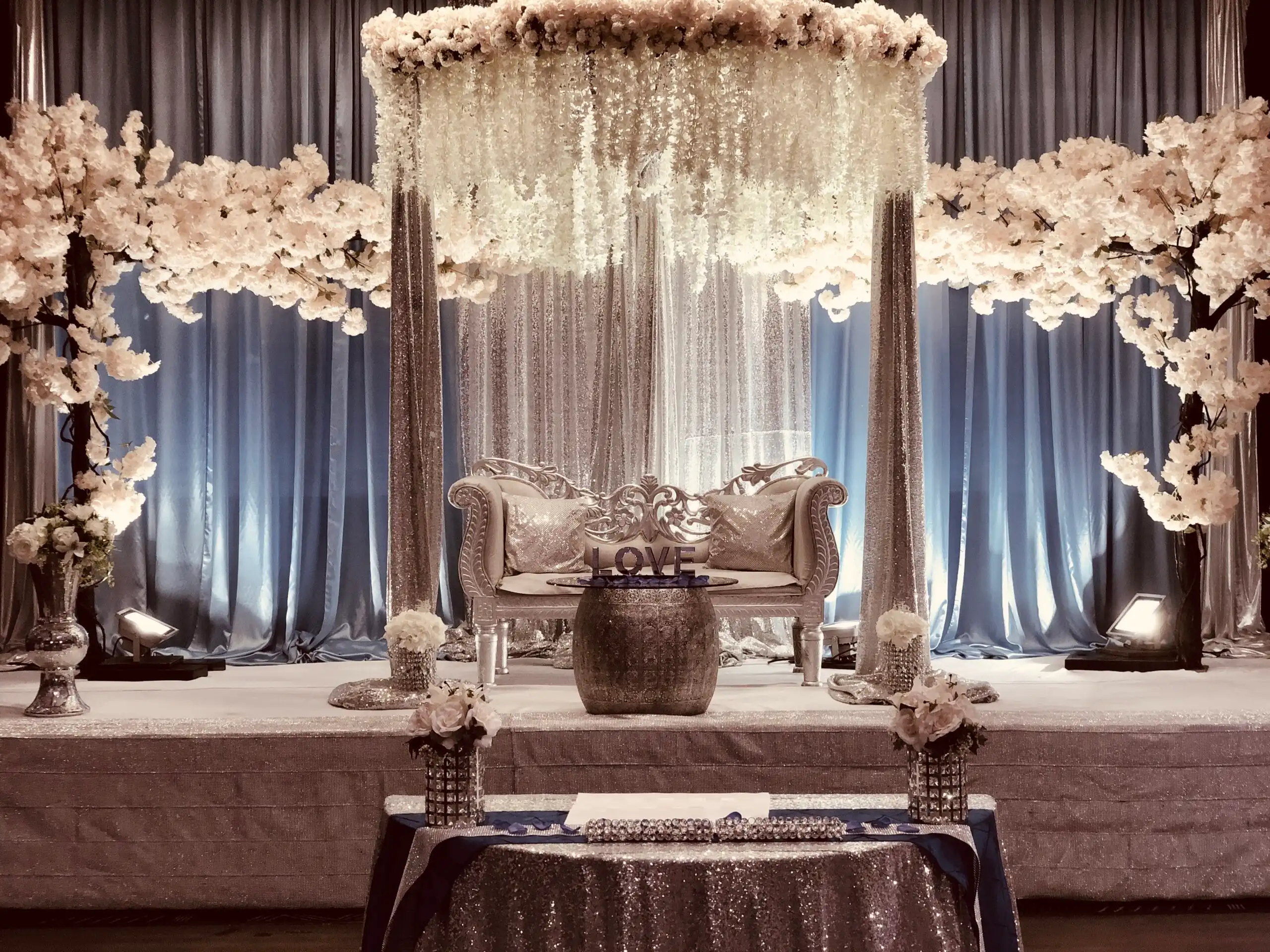 Silver sequin reception stage with wisteria floral canopy · Dream Decorators