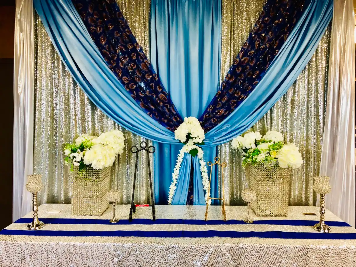 Blue and silver peacock backdrop with crystal vases · Dream Decorators