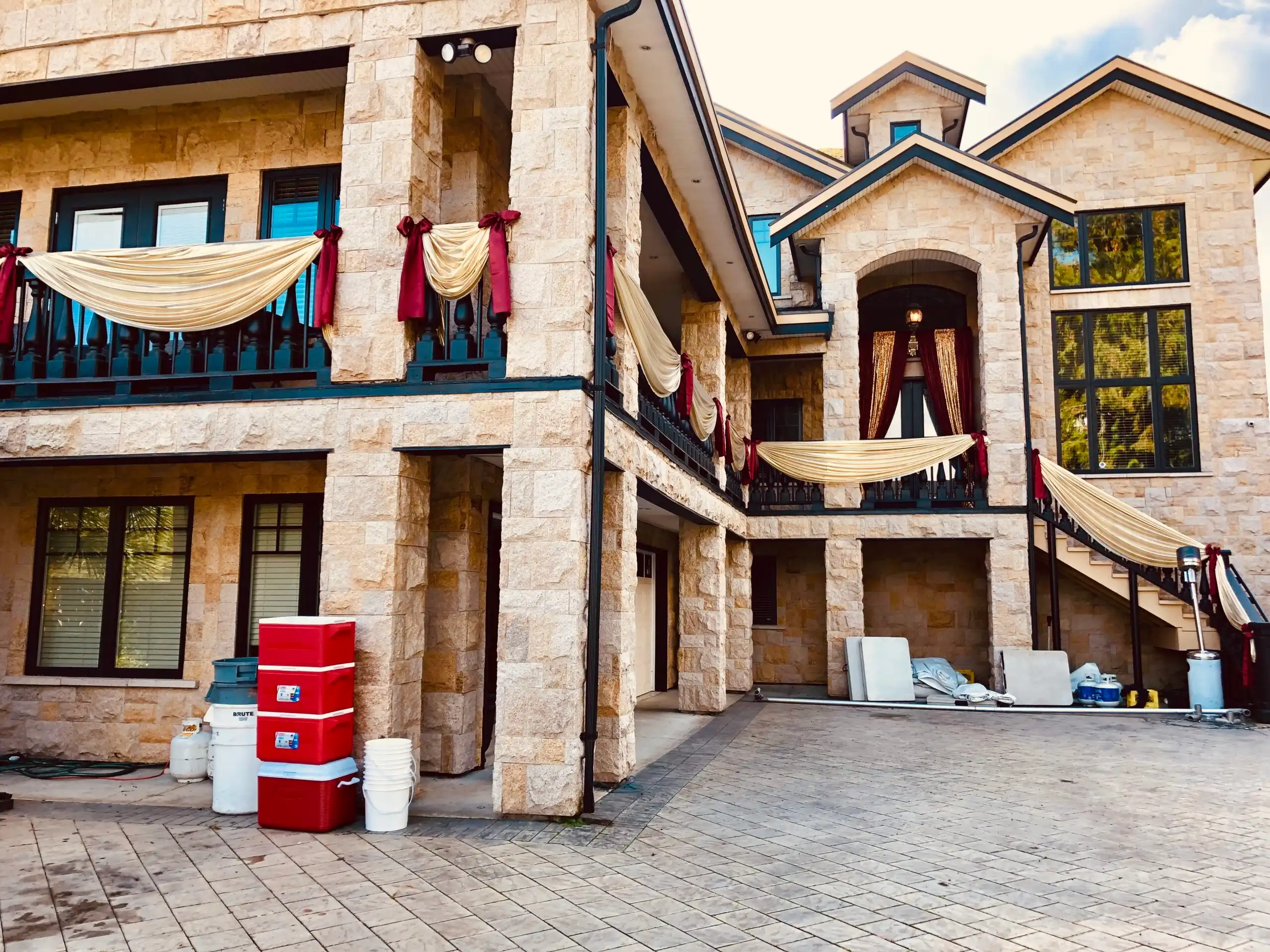 Gold and red exterior home wedding draping · Dream Decorators