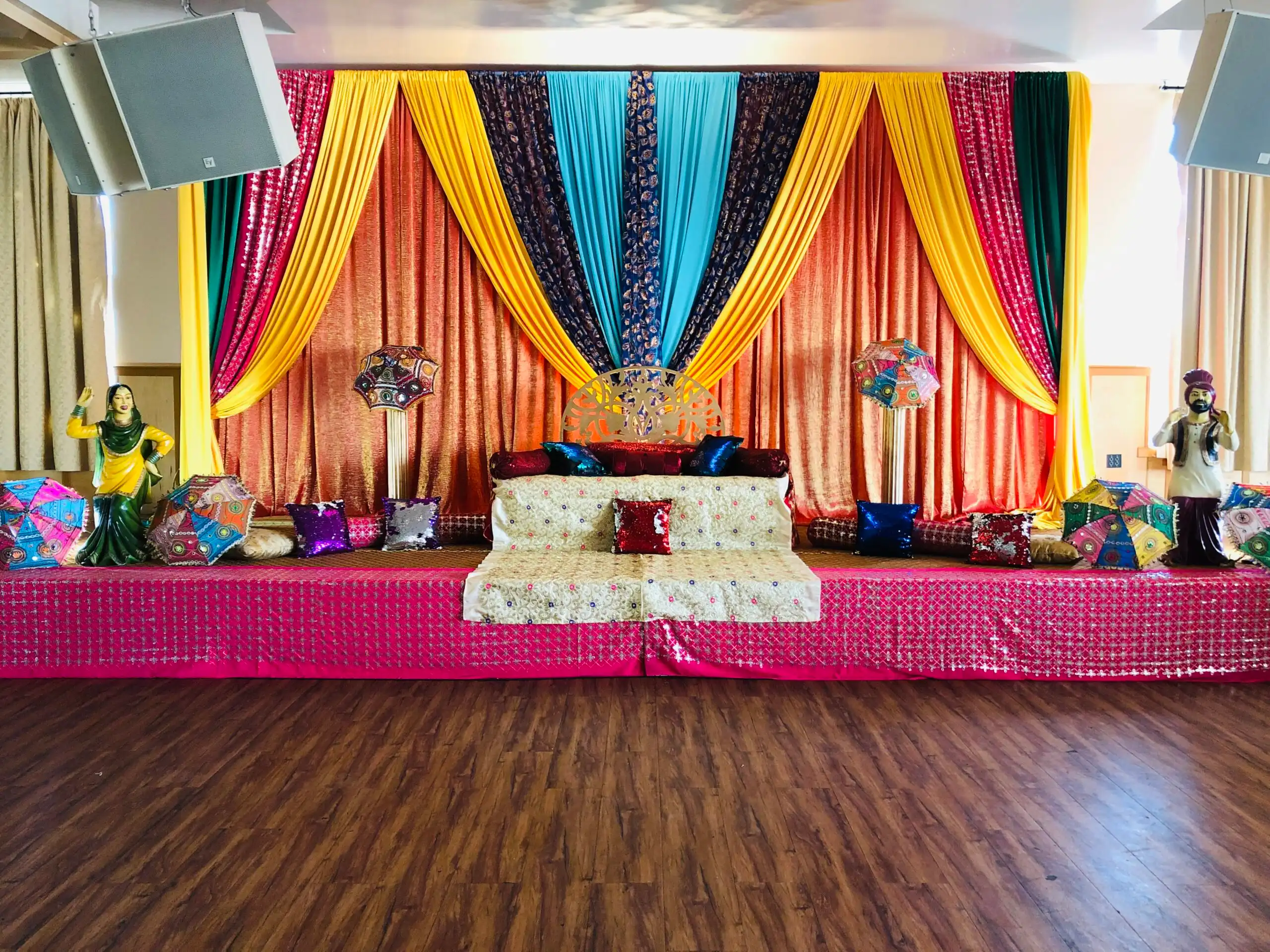 Pink sequin Punjabi maiyan stage with folk statues · Dream Decorators