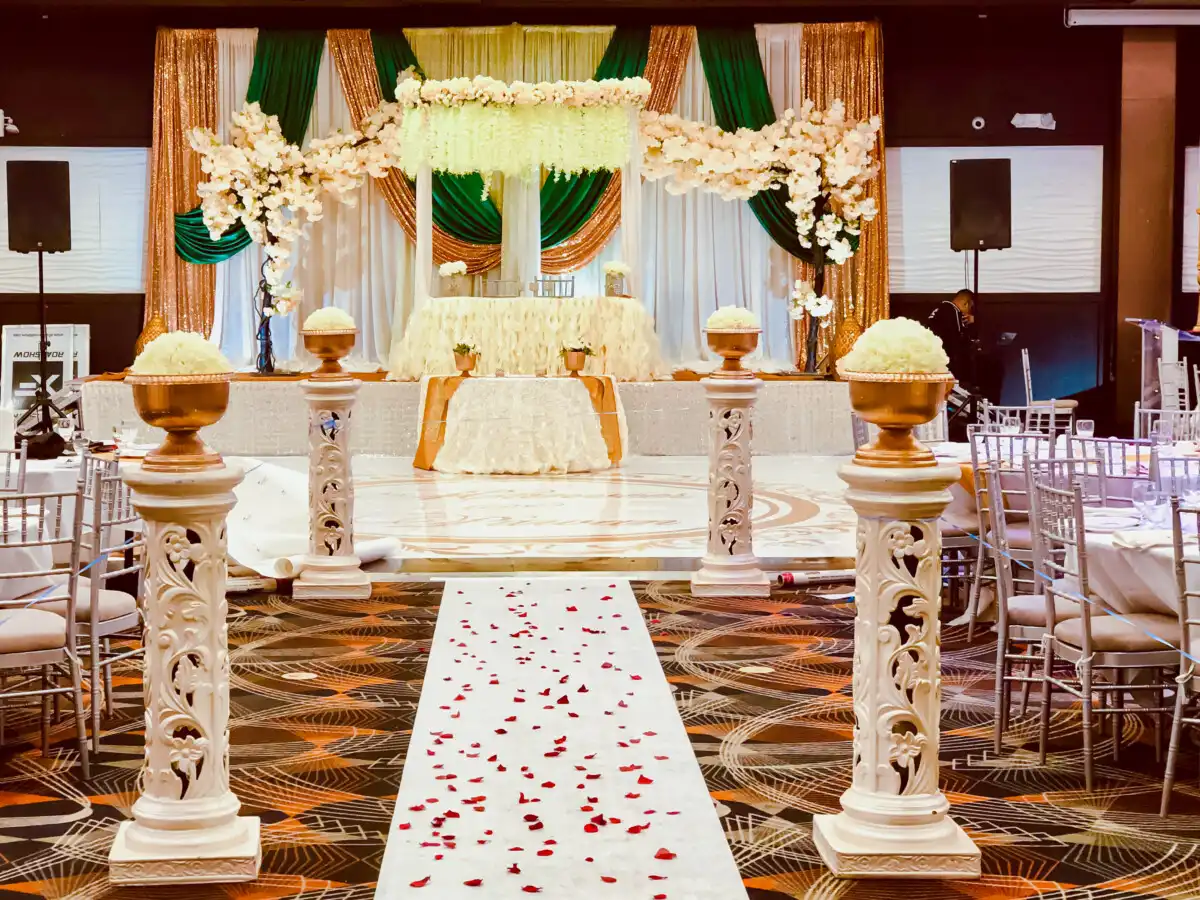 Emerald and gold stage with floral pillars · Dream Decorators