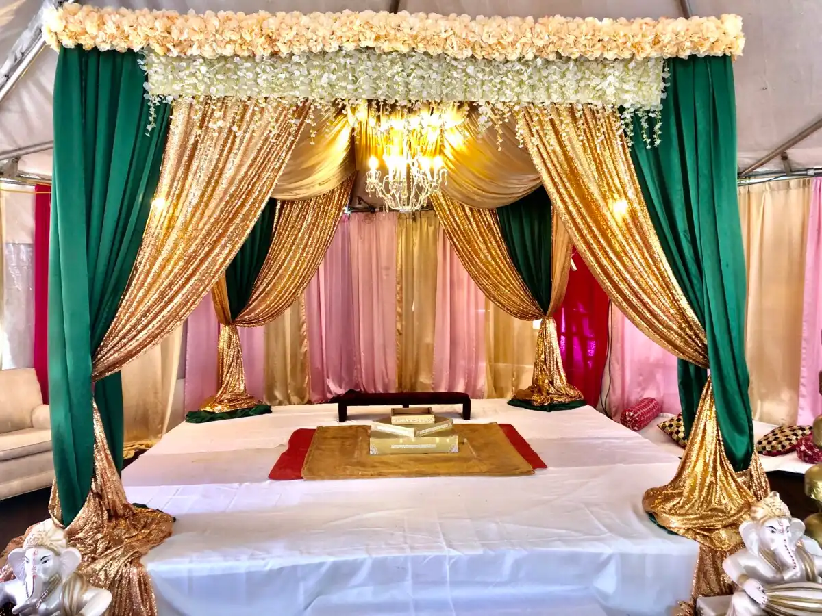 Emerald and gold mandap with crystal chandelier · Dream Decorators