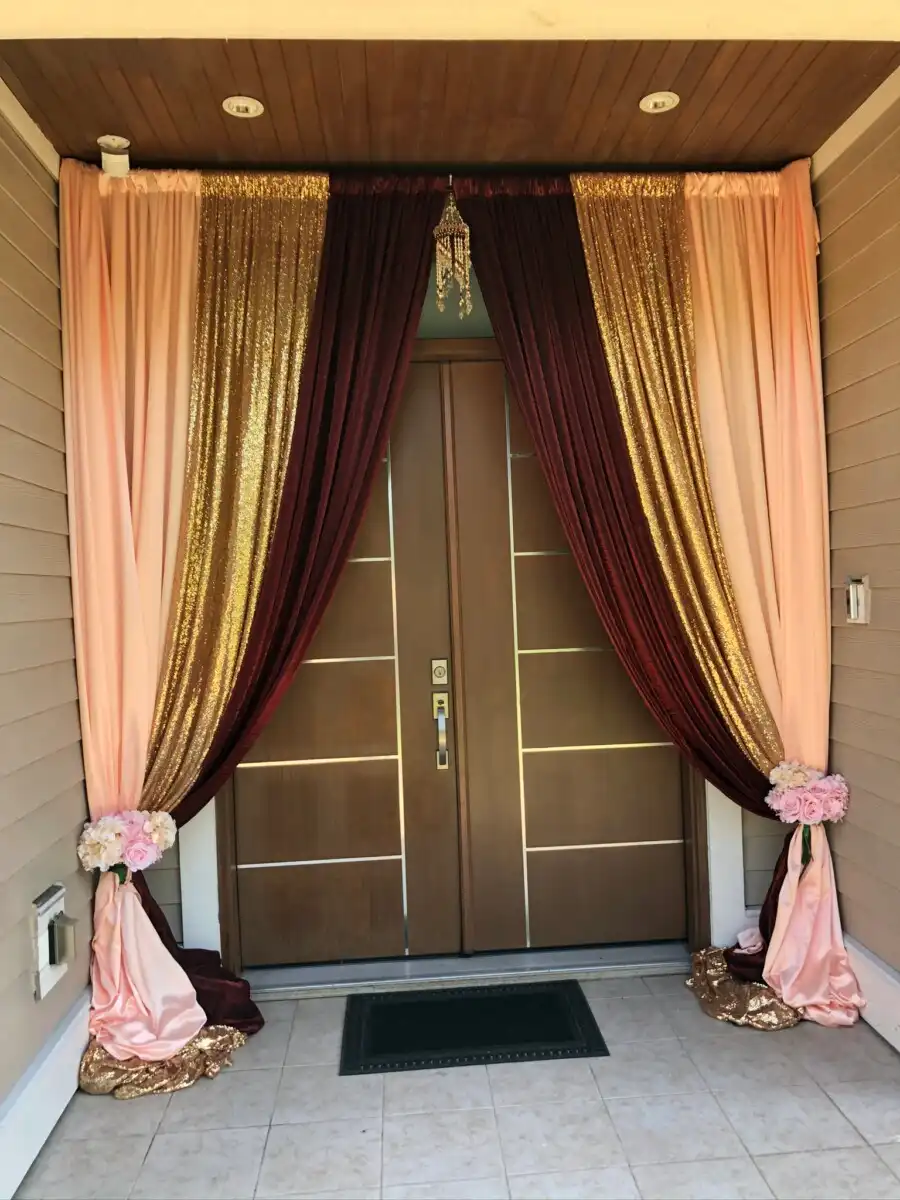 Peach gold and maroon home entrance with chandelier · Dream Decorators