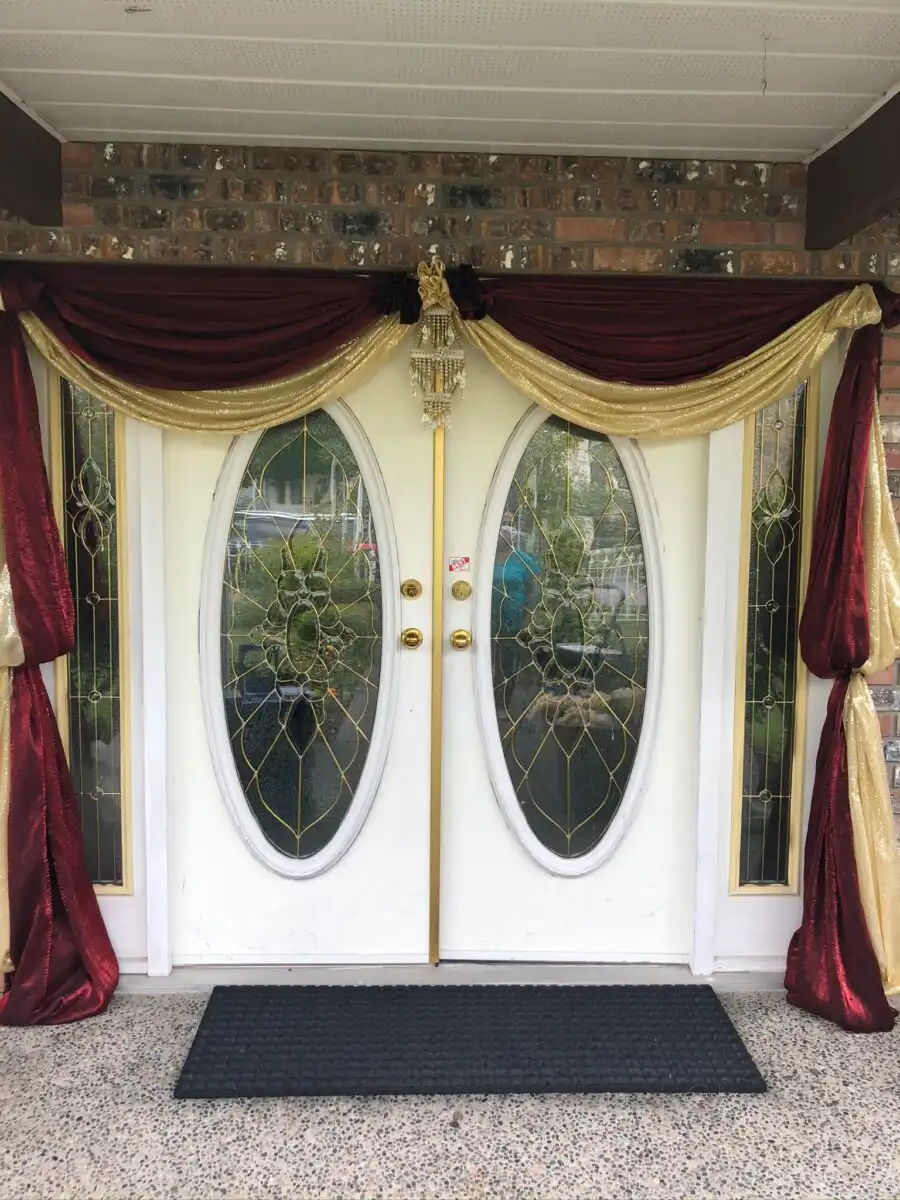 Maroon and gold home entrance with crystal ornament · Dream Decorators