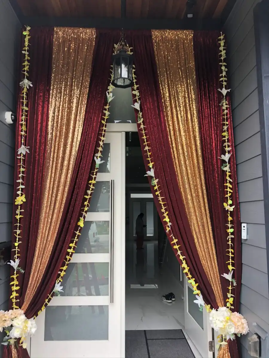 Maroon and gold home entrance with marigold garlands · Dream Decorators
