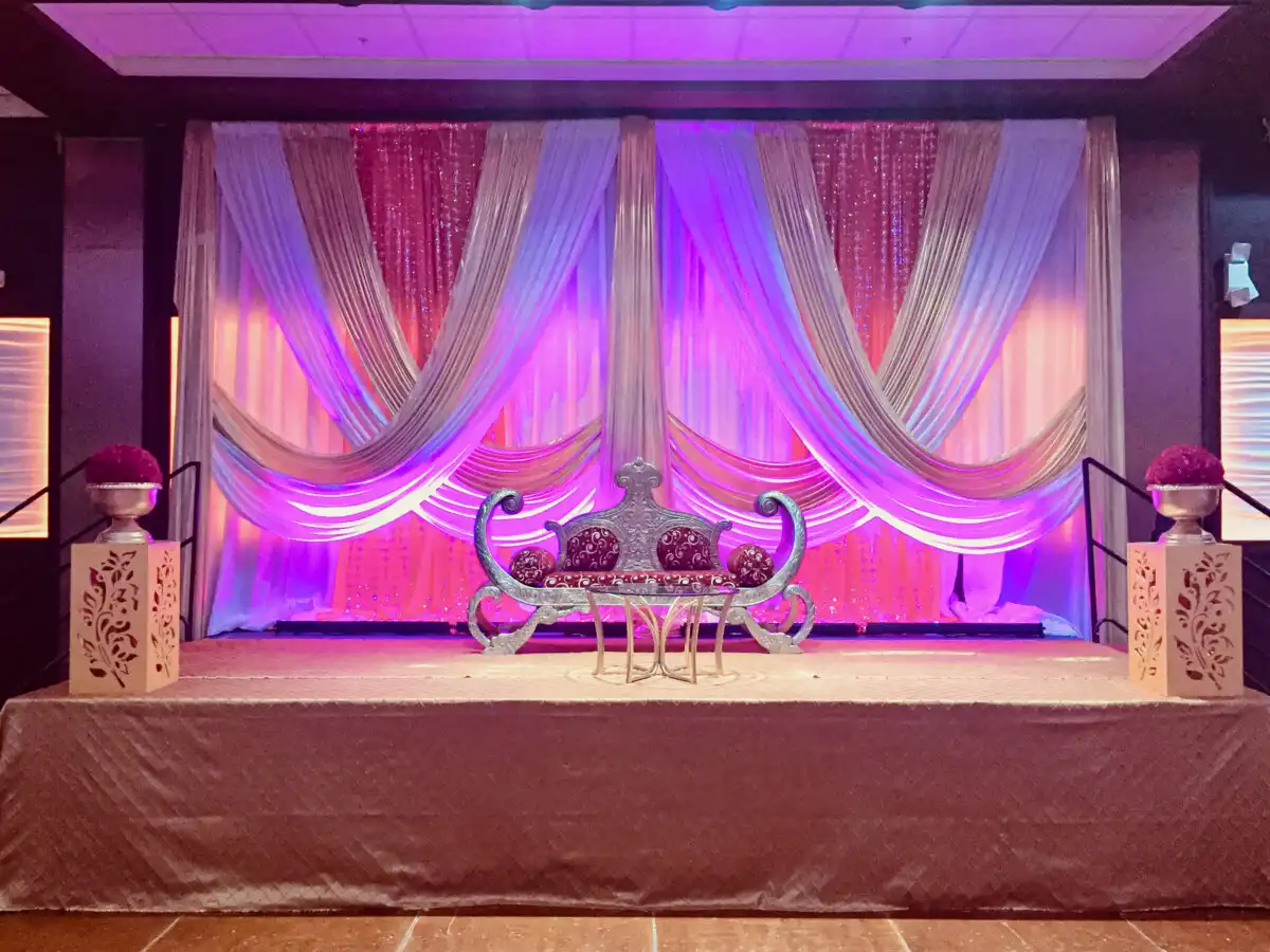 Silver loveseat with purple uplighting · Dream Decorators