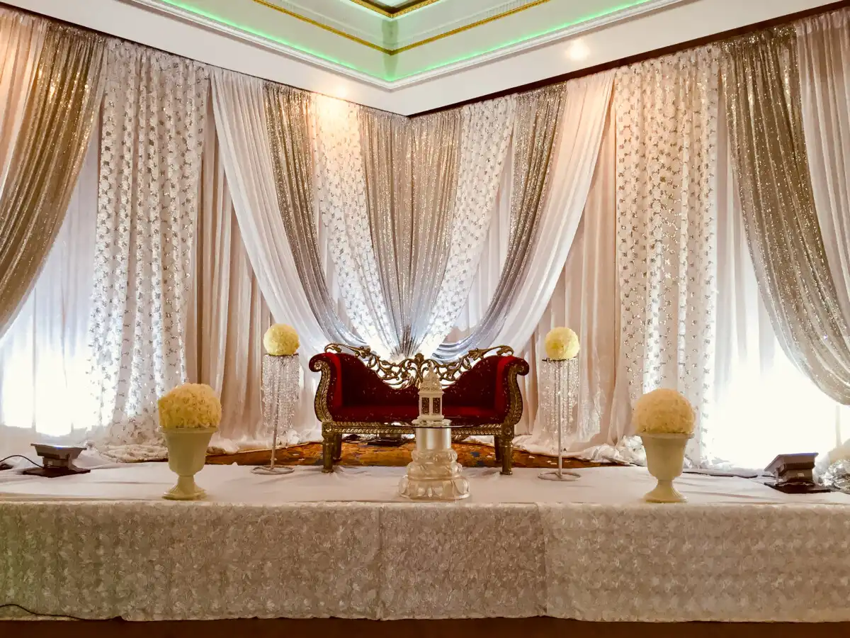 Red and gold loveseat with silver corner backdrop · Dream Decorators
