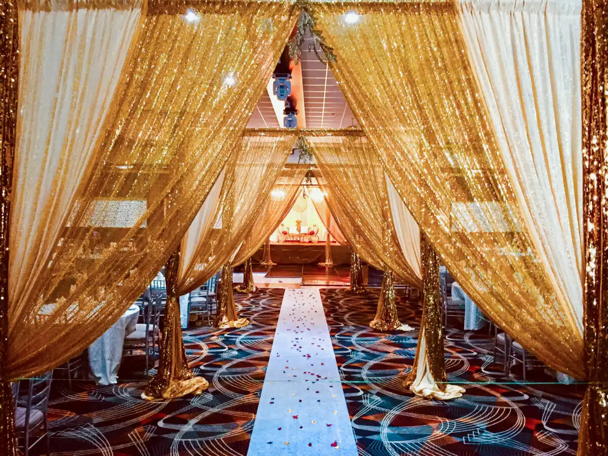 Grand gold sequin entrance with petal aisle · Dream Decorators
