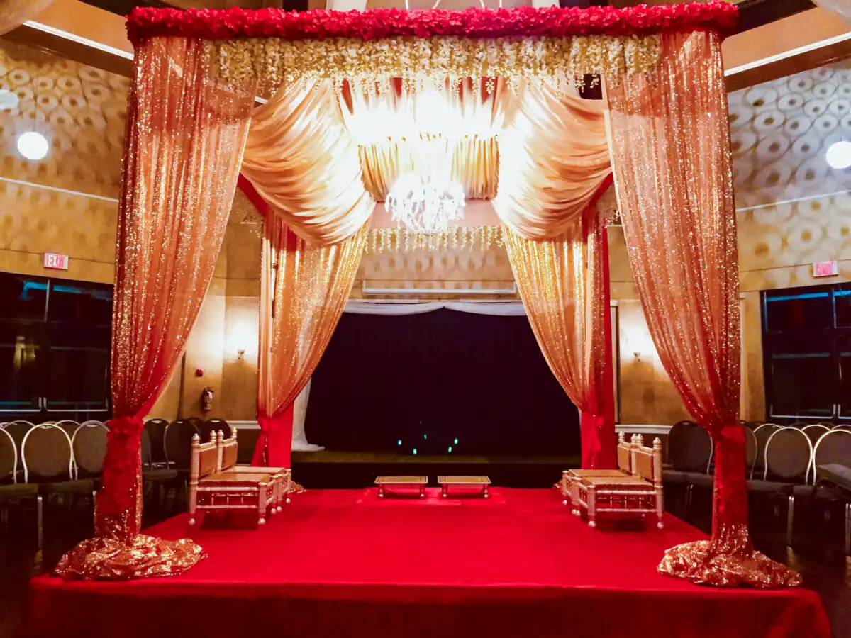 Red and gold sequined mandap with chandelier · Dream Decorators Surrey