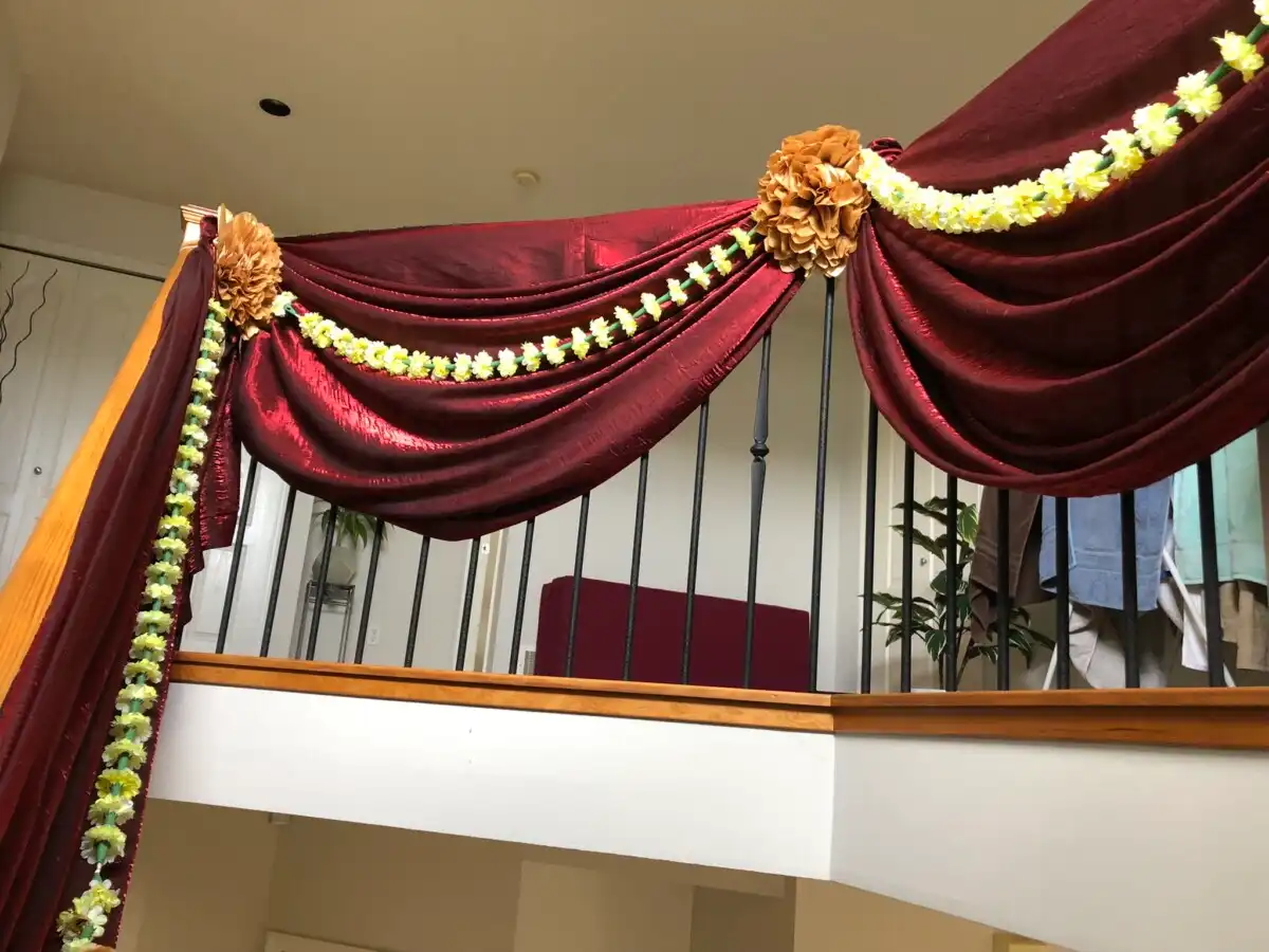 Maroon and yellow home staircase garland draping · Dream Decorators