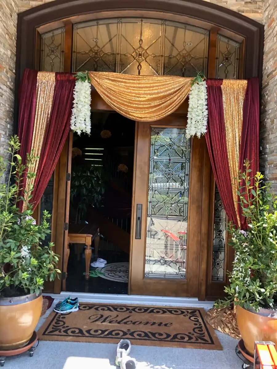 Burgundy and gold sequined home entrance with white florals · Dream Decorators Surrey