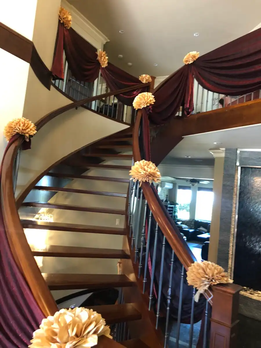 Burgundy and gold staircase draping with fabric flowers · Dream Decorators