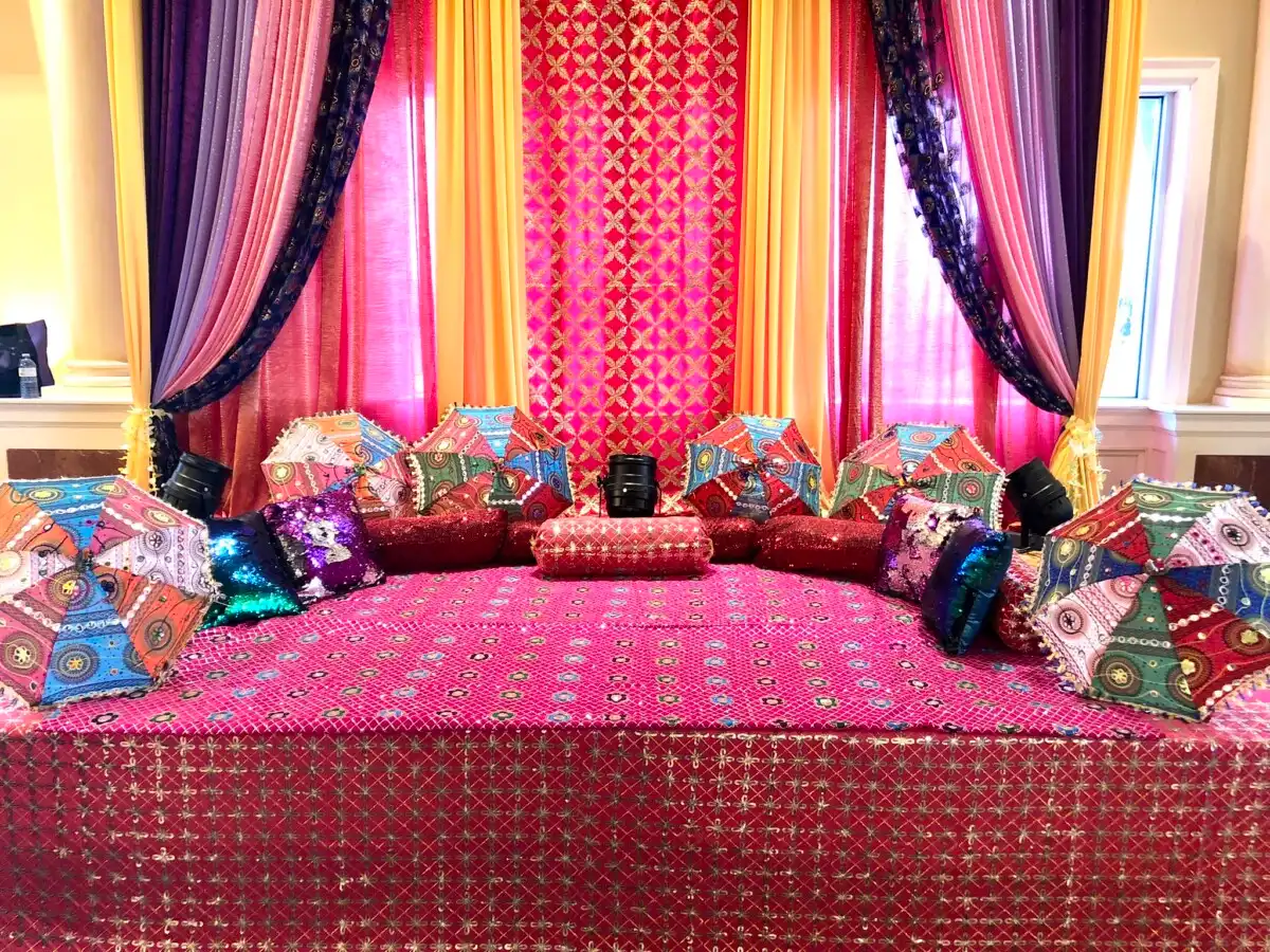 Pink mehndi seating with traditional umbrellas · Dream Decorators