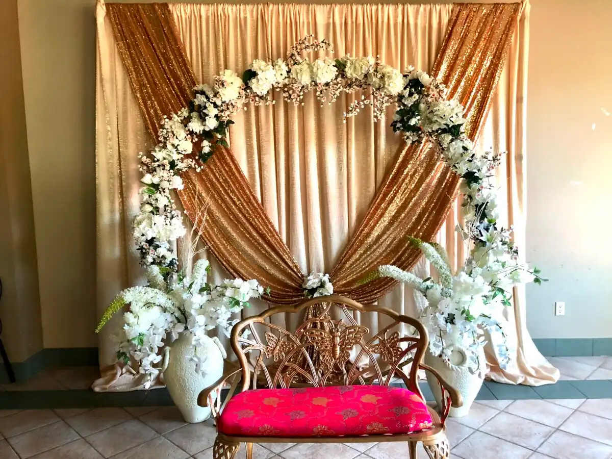 Gold and pink backdrop with floral arch · Dream Decorators