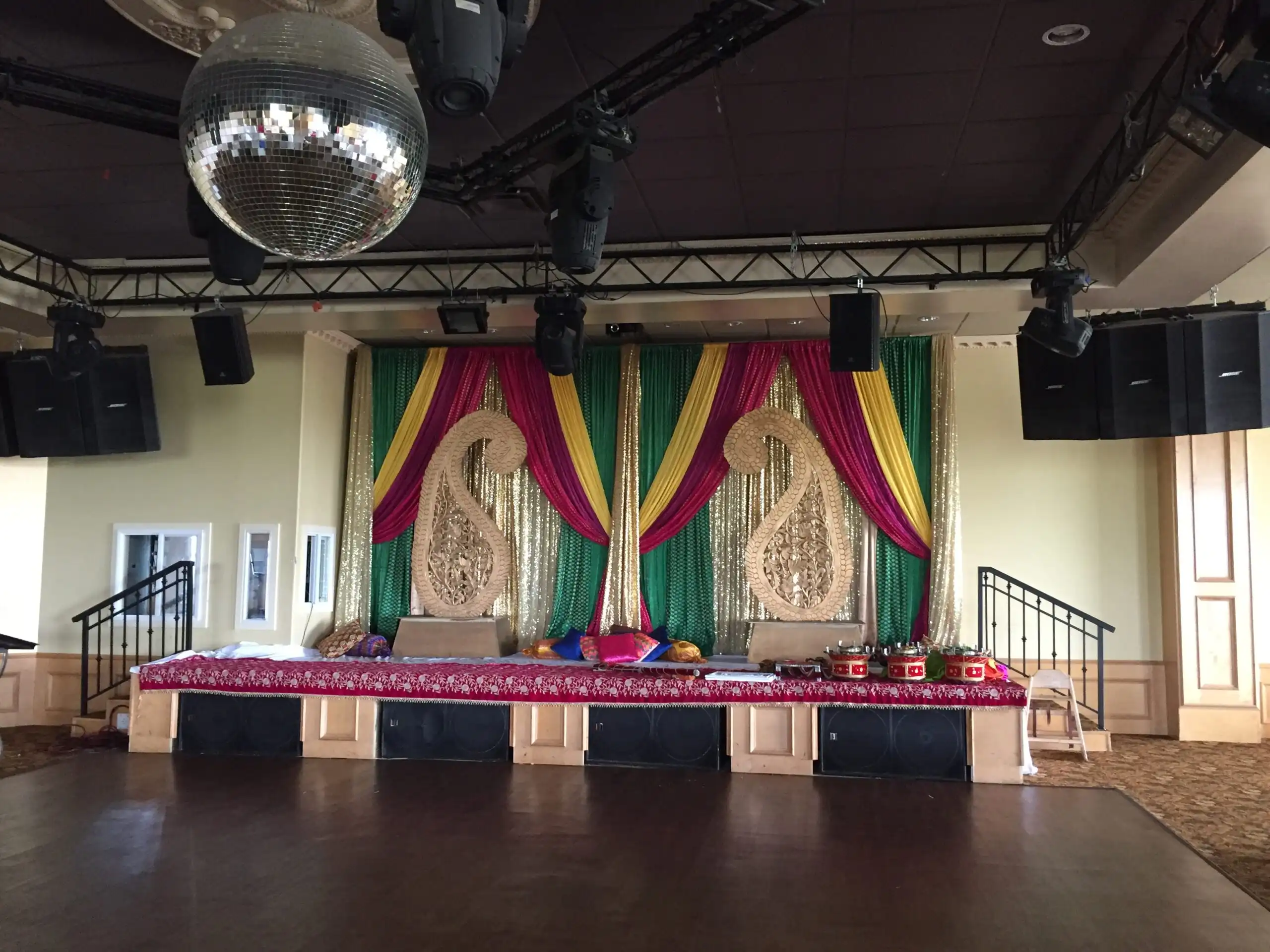 Colorful sangeet stage with gold paisley and disco ball · Dream Decorators