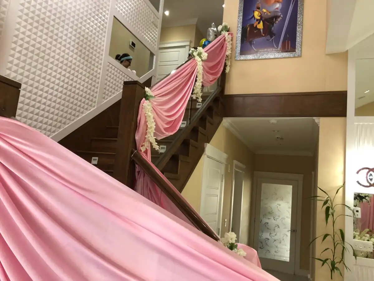 Pink staircase draping with white floral accents · Dream Decorators
