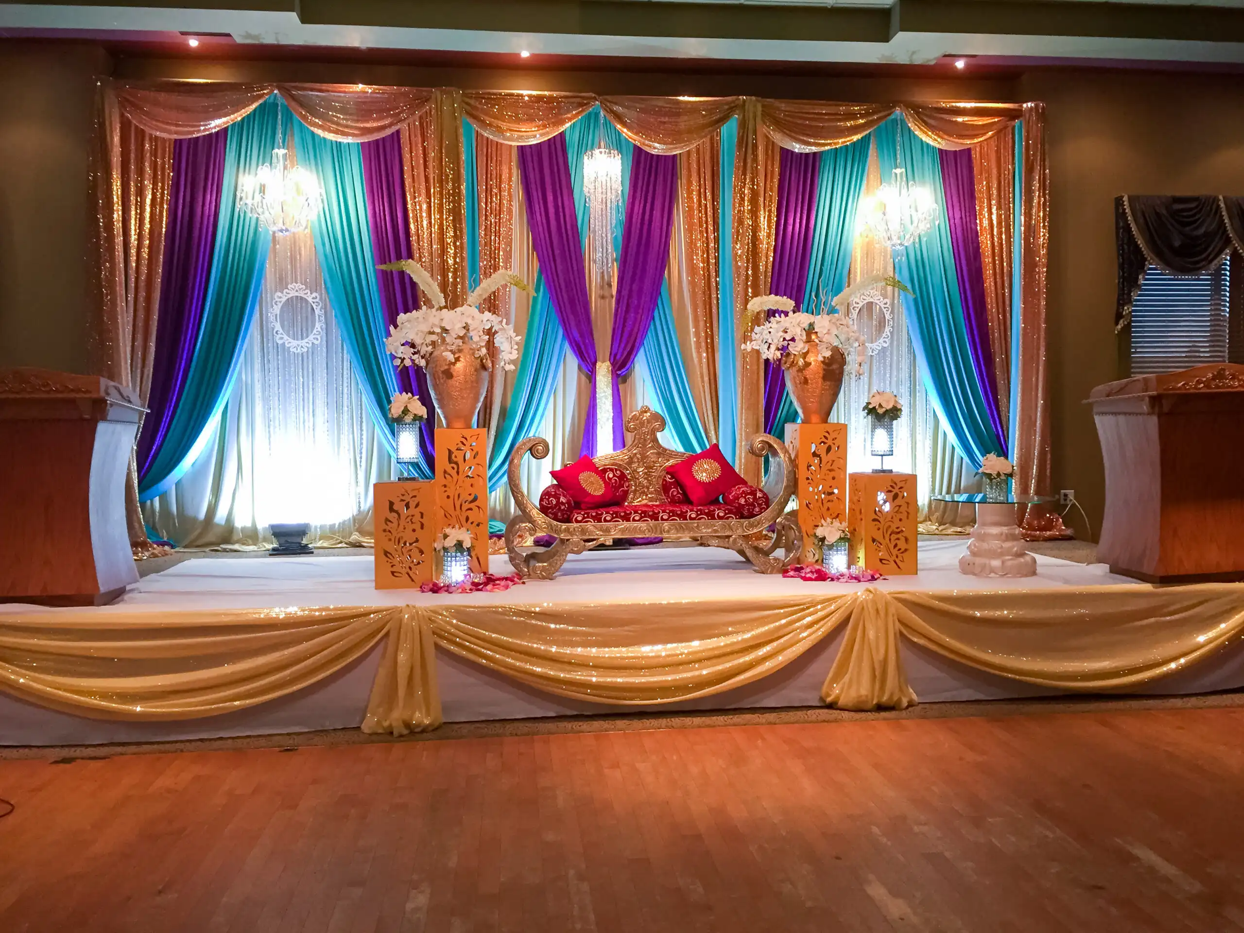 Teal purple and gold sangeet stage with crystal chandeliers · Dream Decorators