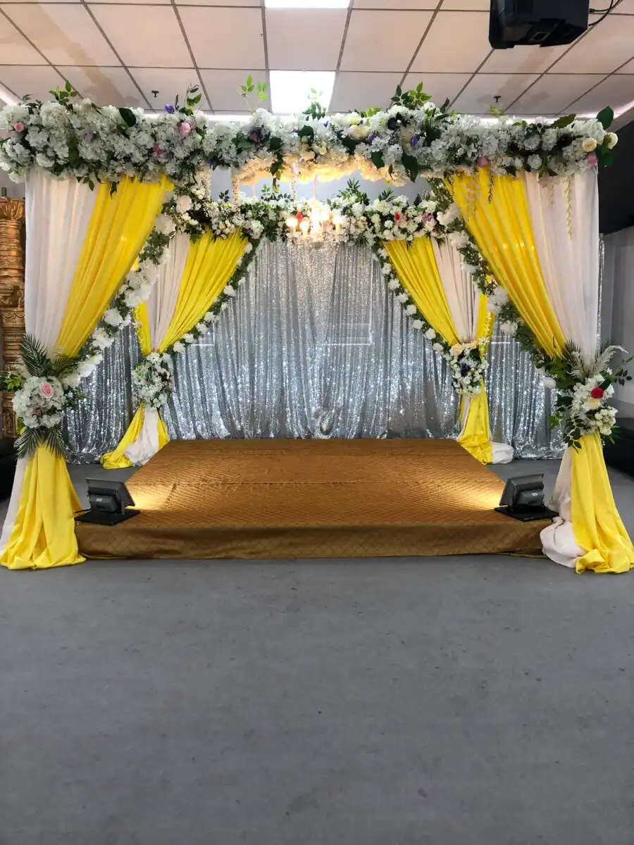 Yellow and white haldi stage with silver backdrop · Dream Decorators