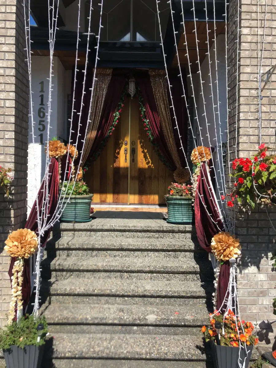 Maroon and gold home entrance with string lights · Dream Decorators Surrey