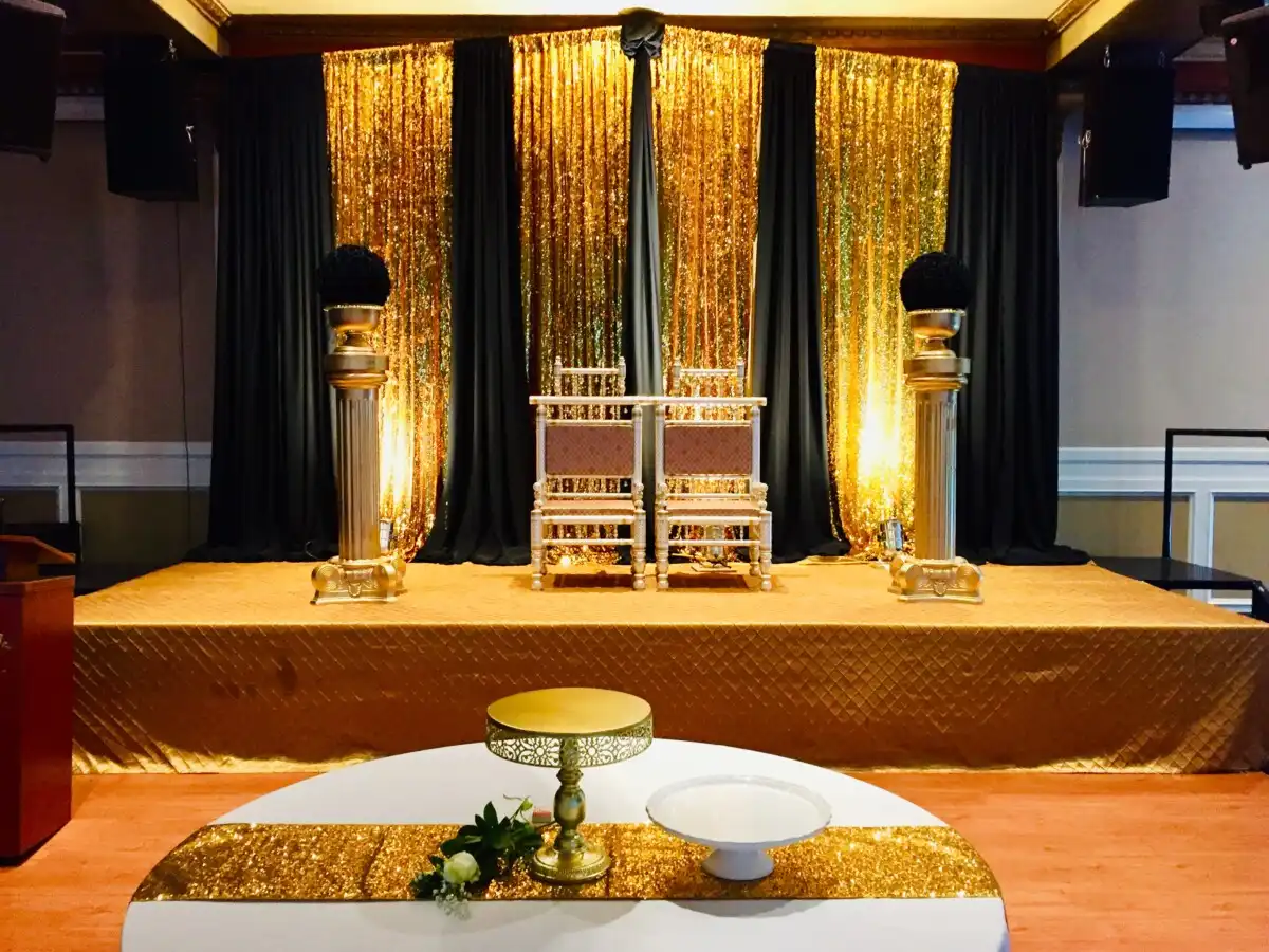 Gold and black sequin reception stage with throne chairs · Dream Decorators